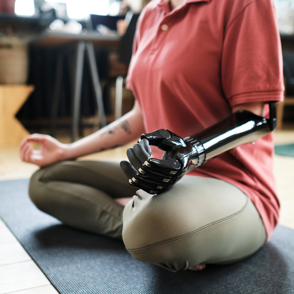 Trägerin einer Armprothese in meditativer Haltung.