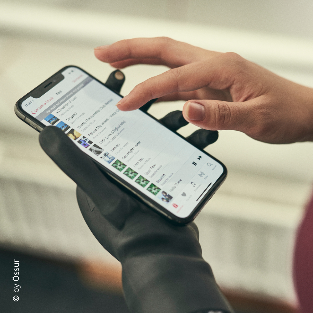 Handprothese bedient ein Smartphone – veranschaulicht die präzise Touchscreen-Funktion der modernen Prothese.