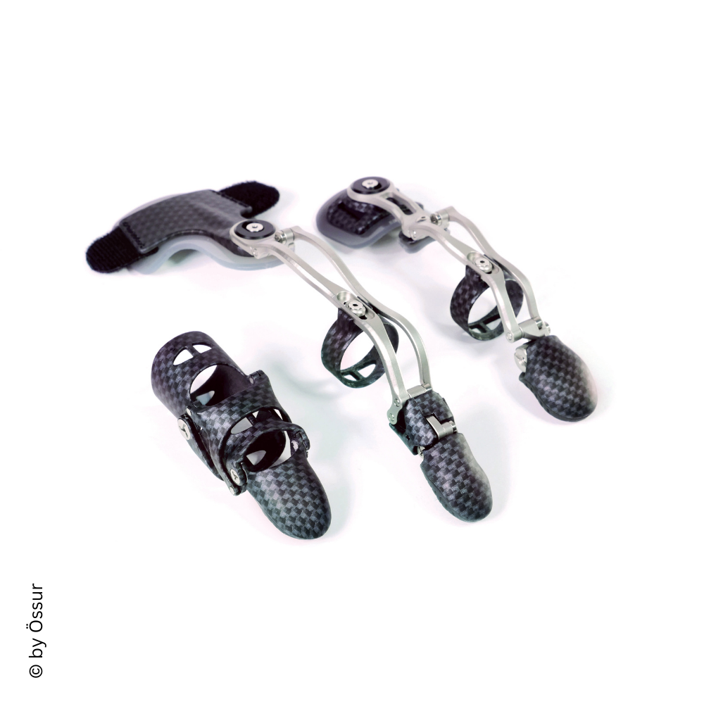 Drei karbonfaserverstärkte Handprothesen mit mechanischen Fingern, die auf einer weißen Oberfläche liegen.